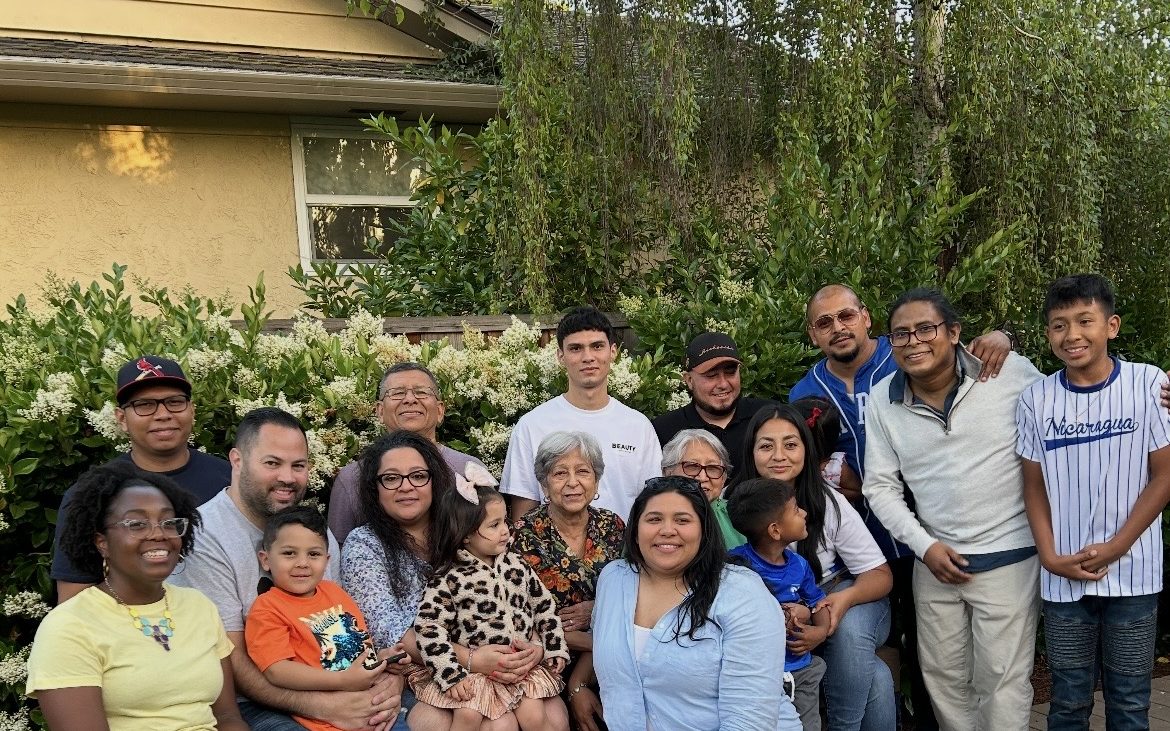 Dr. Keri with her Nicaraguan family, gathered in a garden in the evening light.