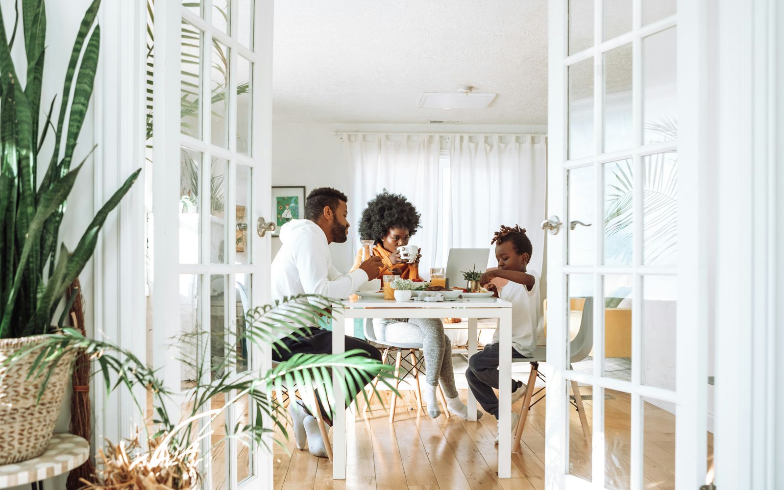 A family at the breakfast table in a bright kitchen.
